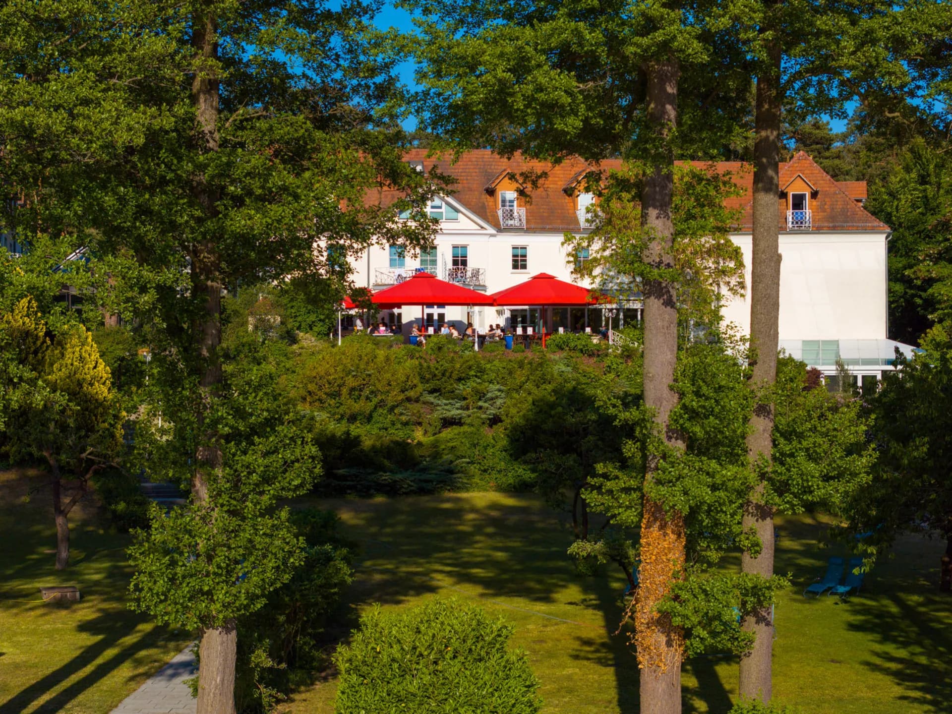 Terrasse des Residenz Seehotels mit roten Sonnenschirmen